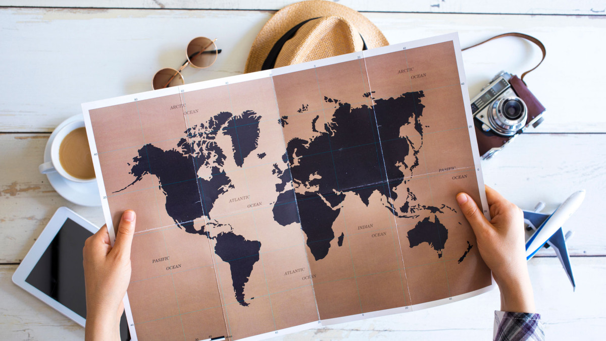 Mensch hält Weltkarte in der Hand