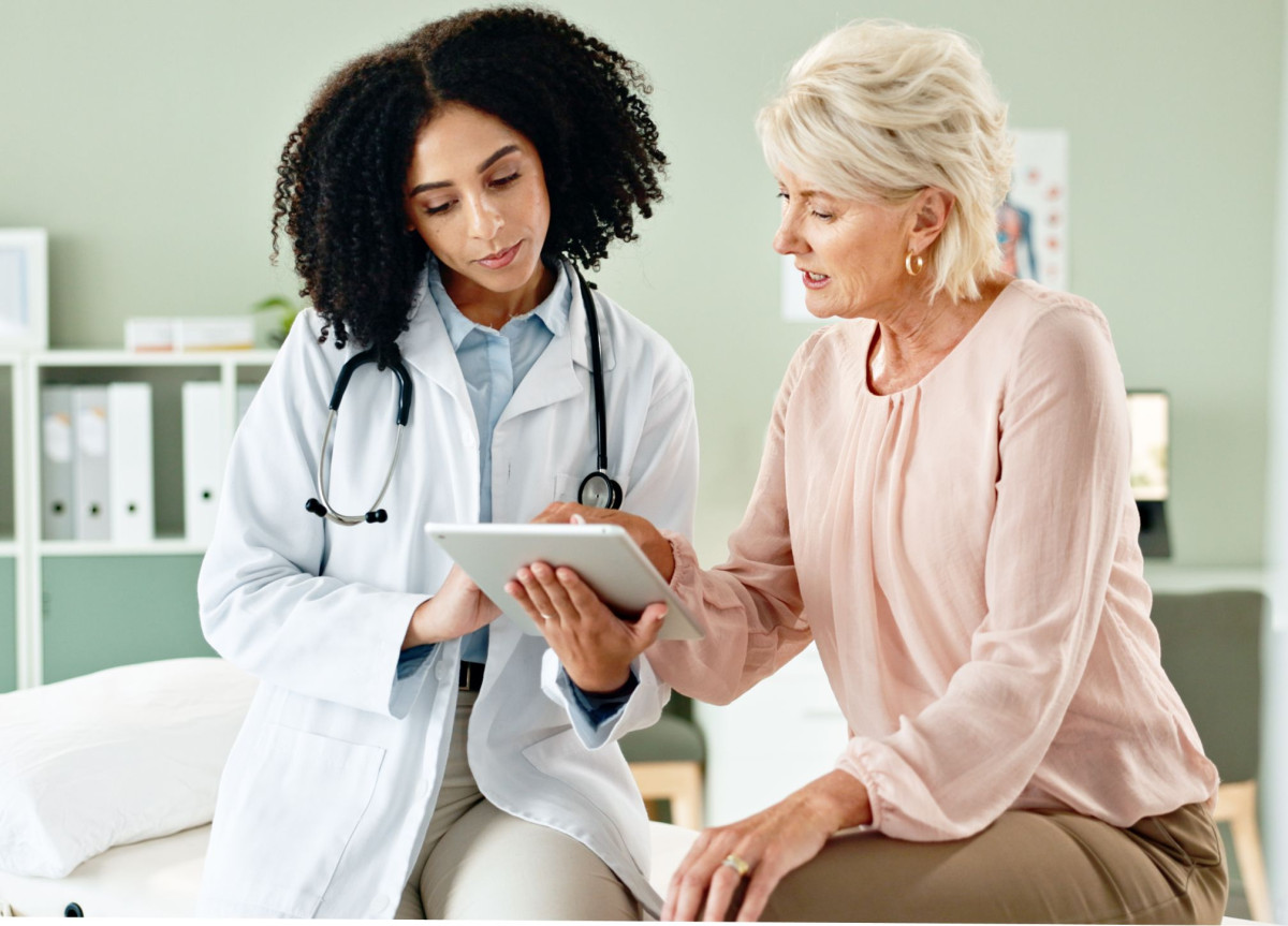 Eine Ärztin zeigt einer Patientin etwas auf einem Tablet