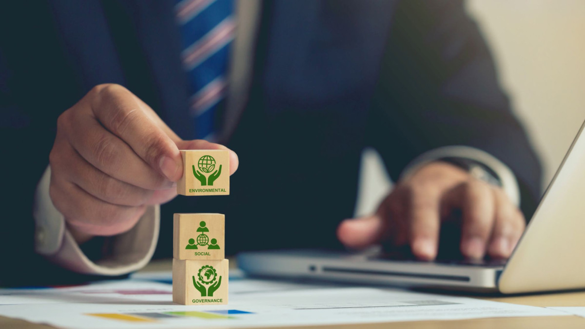 Geschäftsmann hält Holzwürfel mit ESG-Symbol