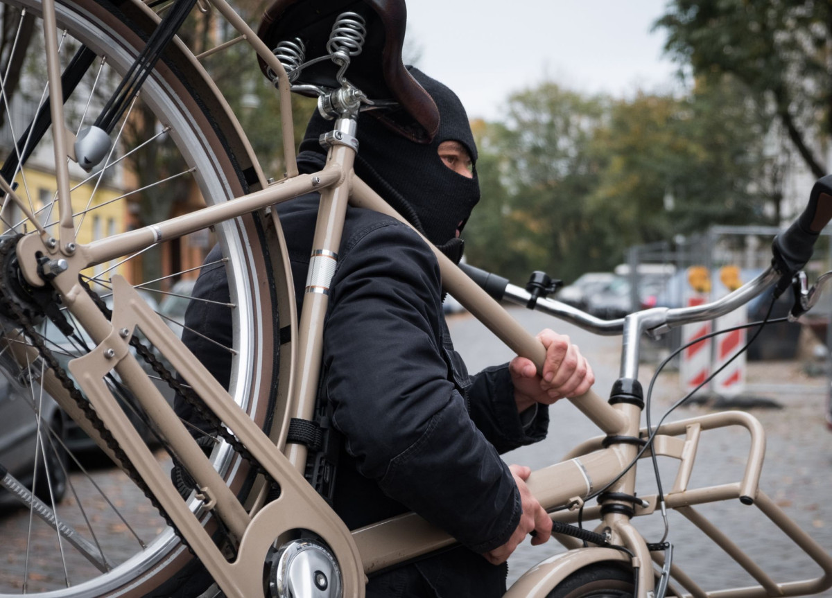 Ein maskierter Mann stiehlt ein Fahrrad