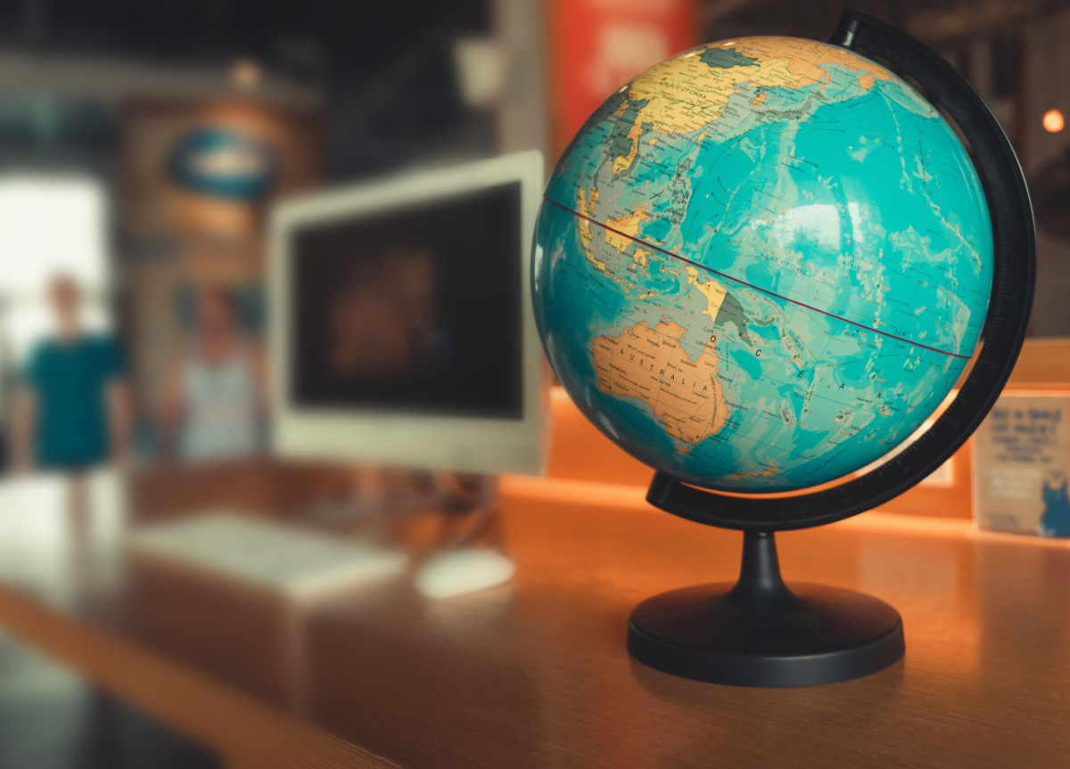 Ein Globus steht neben einem Computer auf einem Tisch