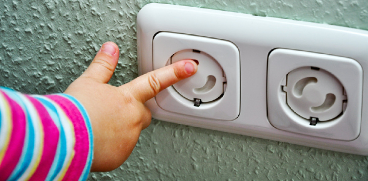 Kind steckt in gesicherte Steckdose